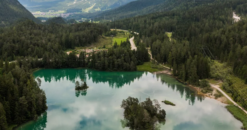 Panorama Weißensee mit zwei bewaldeten, kleinen Inseln in der Mitte.  | © TZA / Sam Oetiker