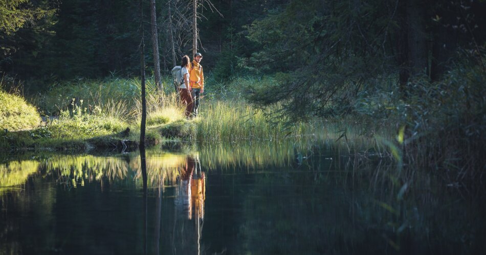 Two hikers stand next to the Loisach.  | © TZA / C. Jorda 