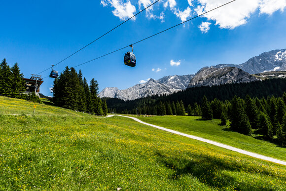 Eine Seilbahn über einer Sommerwiese auf der Ehrwalder Alm. | © Frozen-Lights