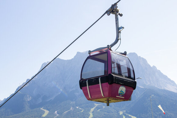 Eine pinke Gondel, im Hintergrund die Zugspitze | © Tiroler Zugspitz Arena/ Giovanni Frey