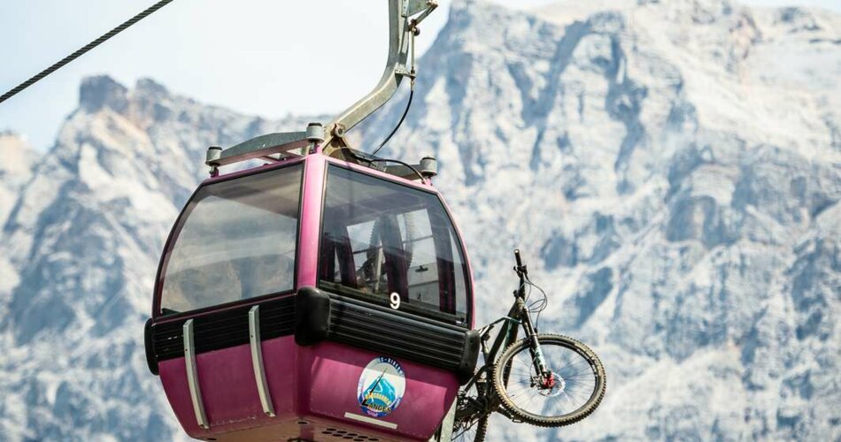 A pink gondola with a bike, with the Zugspitze in the background | © Tiroler Zugspitz Arena/Nikola Radovic