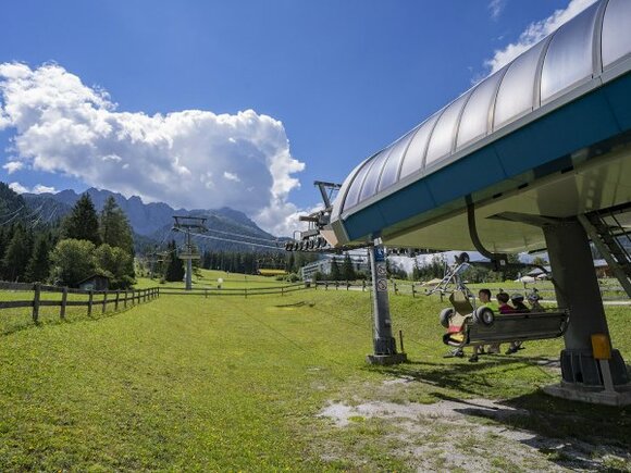 Urlauber auf einem Sessellift der Marienbergbahn im Sommer.