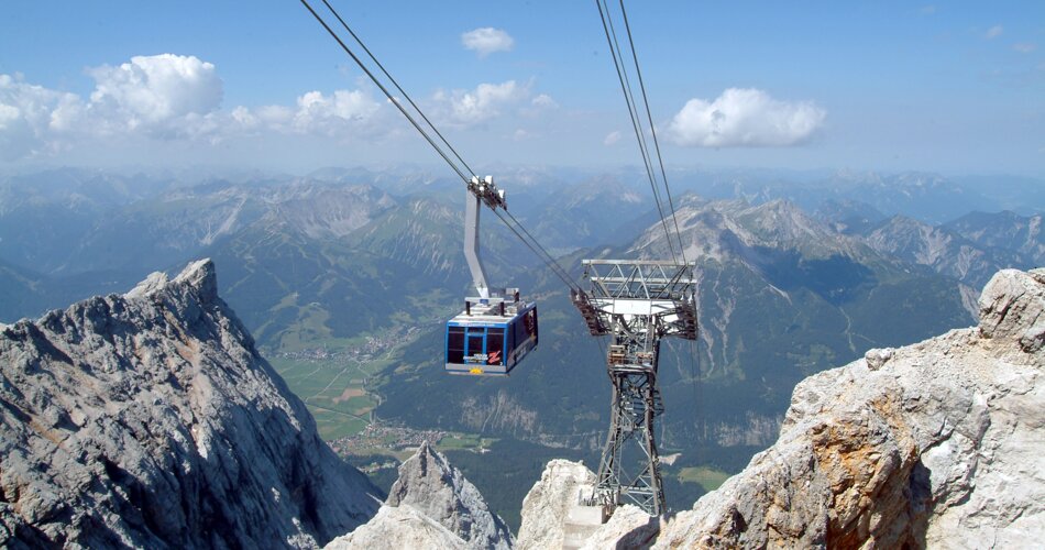 A large gondola lift going to the top of the Zugspitze in the summer.