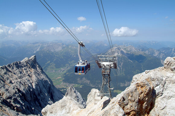 A large gondola lift going to the top of the Zugspitze in the summer.
