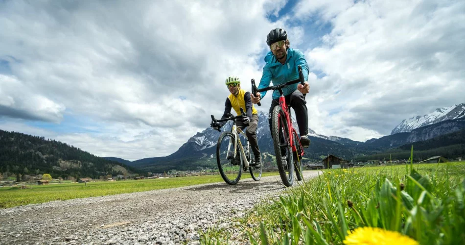 Zwei Gravelbiker auf einem Weg, im Hintergrund die Zugspitze | © Tiroler Zugspitz Arena