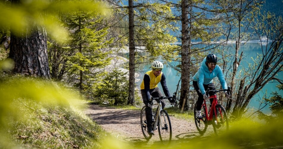 Two cyclists graveling in the forest.