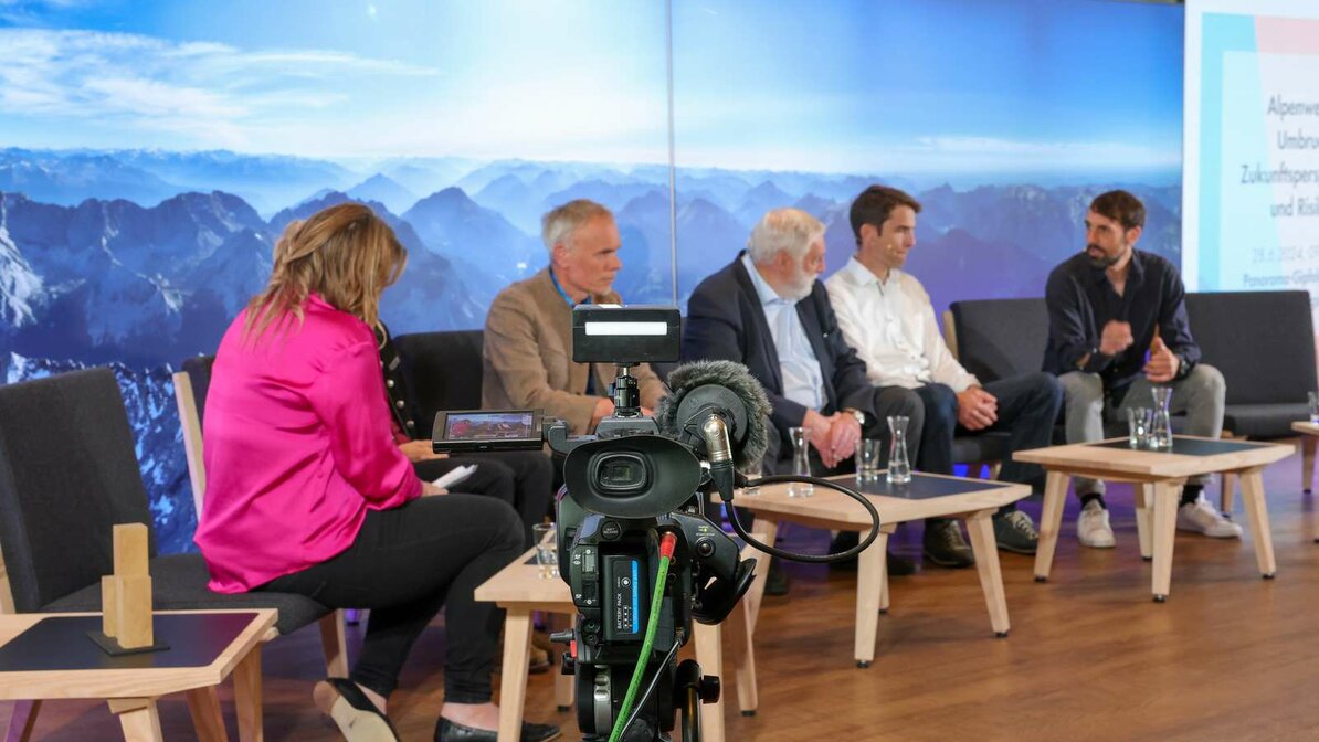 Eine Kamera filmt die Teilnehmer des AlpenKlimaGipfels auf der Bühne | © Tiroler Zugspitz Arena/Zotz Lea 