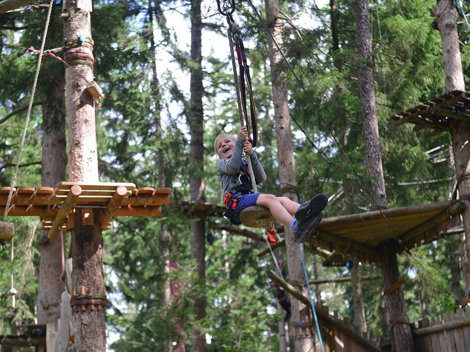 kleiner Junge auf Seilbahn lachend | © Kletterwald Garmisch-Partenkirchen / Peter Krimninger