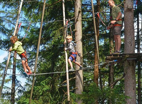 Vater und Söhne an X-Balken | © Kletterwald Garmisch-Partenkirchen / Peter Krimninger