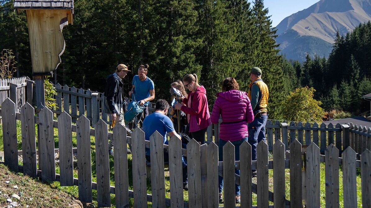 Menschen hinter Zaun mit Sommerpanorama | © Lea Zotz / Tiroler Zugspitz Arena