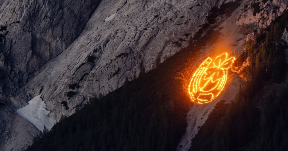 A picture consisting of small fires on the mountainside. The picture shows a horseshoe and a shamrock inside.  | © Danijel Janovovic | Tiroler Zugspitz Arena