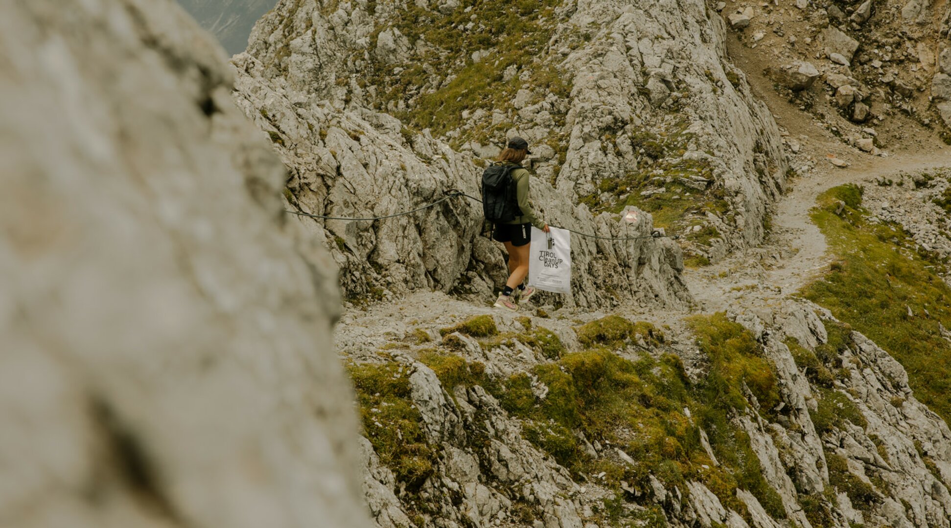 Person with a garbage bag | © Patron Plasticfree Peaks _ Lena Everding Photo