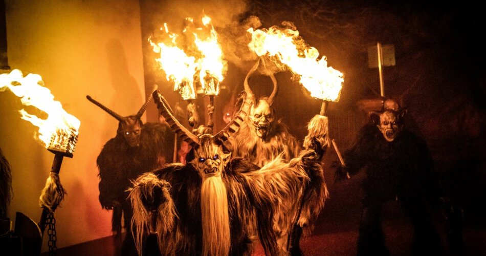 Several people with typical tyrolean Krampus costumes and masks, carrying torches in their hands | © Tiroler Zugspitz Arena/Moos Tuifl Ehrwald