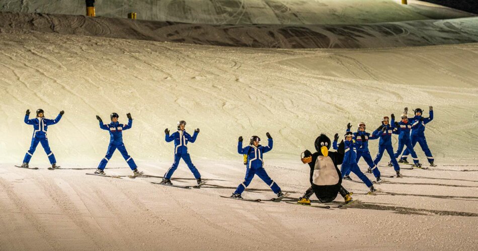 Skiers in a formation and a penguin mascot | © Tiroler Zugspitz Arena