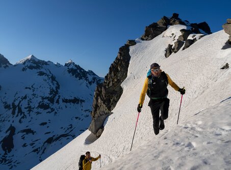 Teilnehmer der Red Bull X-Alps auf einem Schneefeld im Hochgebirge | © ©zooom/ Lukas Pilz 