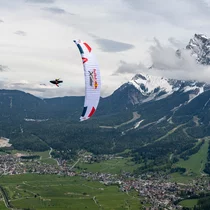 A paraglider from the Red Bull x-Alps, the Zugspitze in the background | © zooom/Felix Woelk