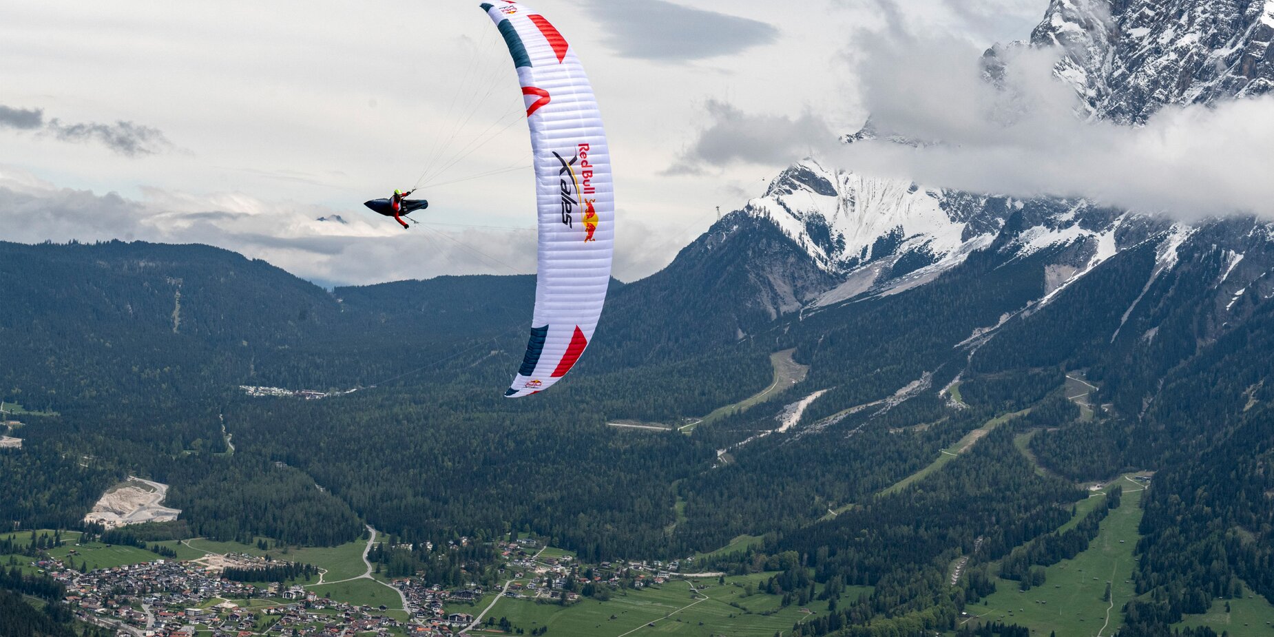 A paraglider from the Red Bull x-Alps, the Zugspitze in the background | © zooom/Felix Woelk