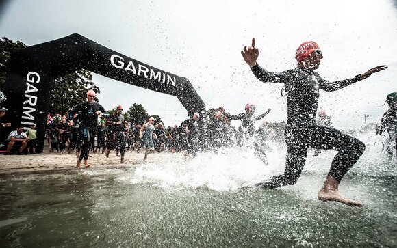 Menschen laufen durch einen Bogen in das Wasser | © WAPICS - Andreas Willdoner