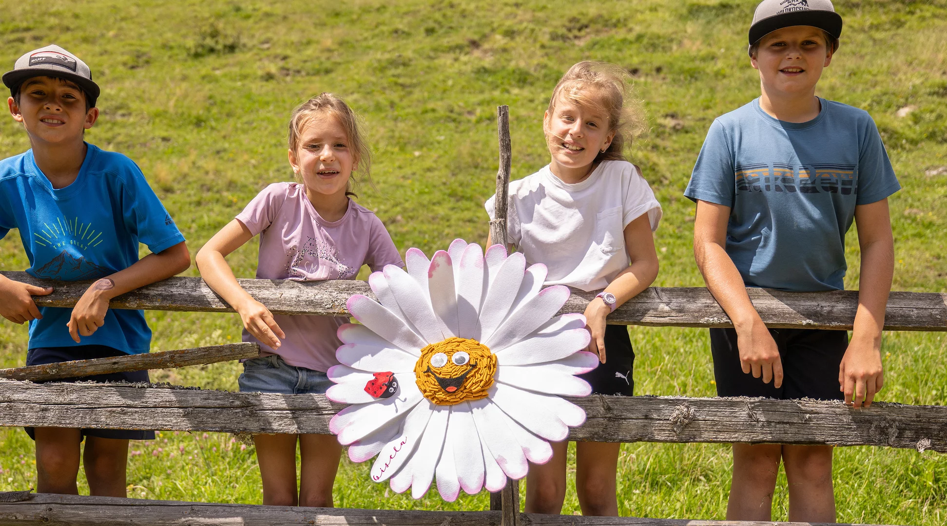 Kinderprogramm | © Johannes Sautner / Shootandstyle Mehrere Kinder stehen an einem Zaun, in der Mitte das Maskottchen des Kinderprogramms Gisela Gänseblümchen | © Johannes Sautner / Shootandstyle