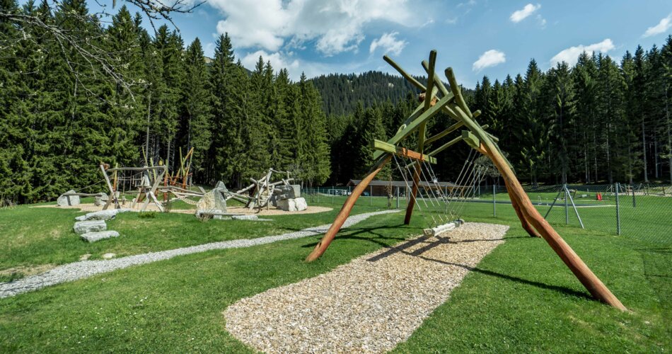 Moderner Spielplatz auf einer Wiese vor einem Wald | © TZA