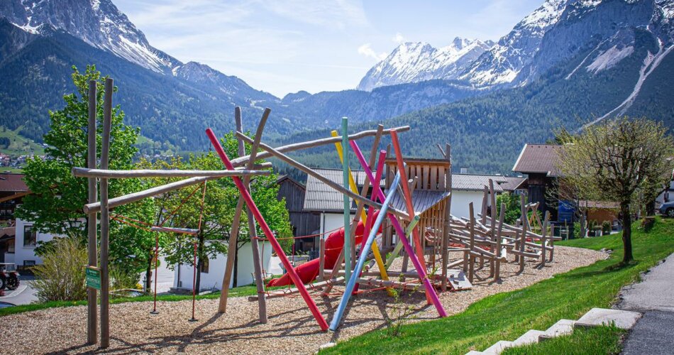 Modern playground with colorful elements in front of a mountain panorama | © Tiroler Zugspitz Arena