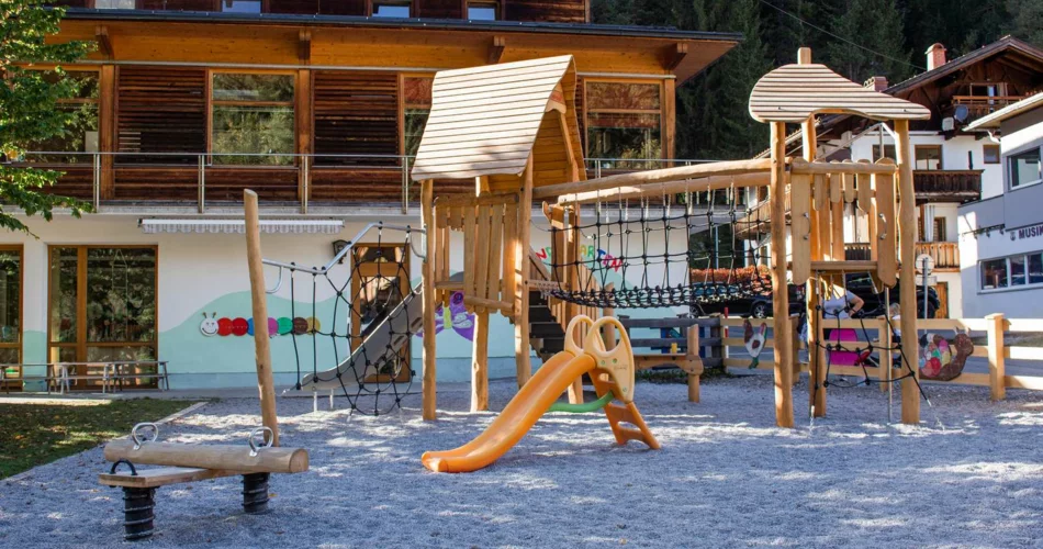 Moderner Spielplatz auf Kies vor einem Haus | © TZA
