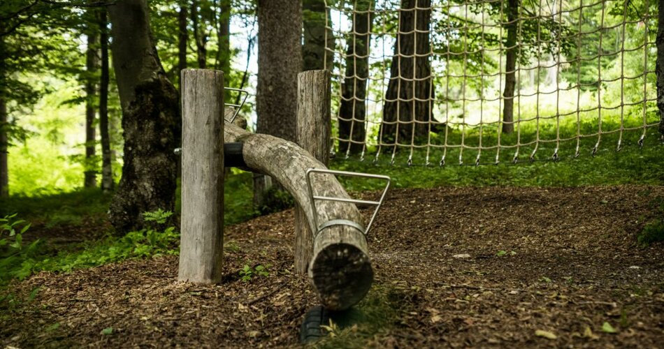 Wooden seesaw and a climbing net surrounded by forest | © TZA