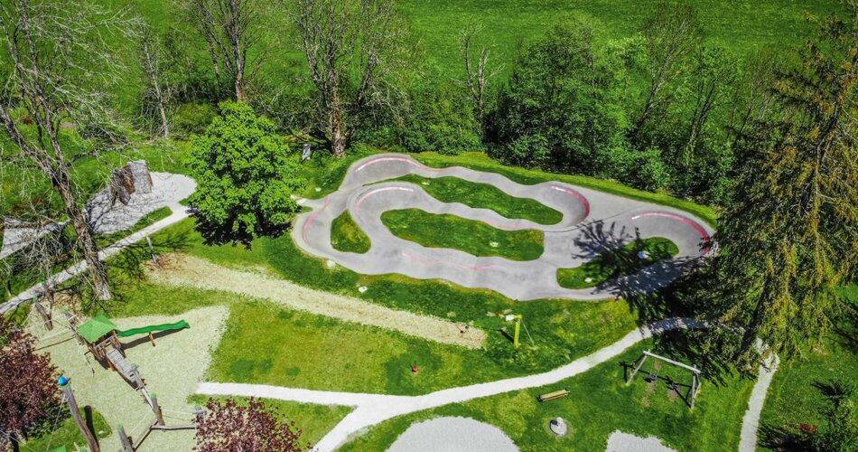 View from above of the pump track next to a playground surrounded by meadows | © TZA