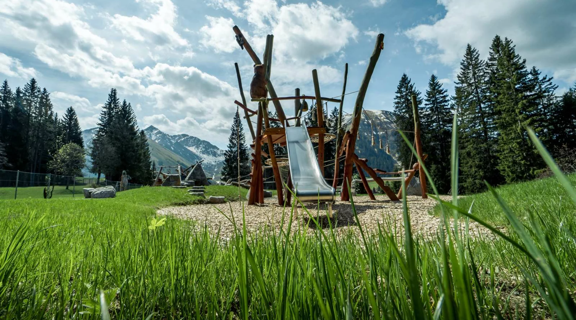 Spielplatz Bärenarena | © TZA Moderner Spielplatz mit Rutsche vor Bergpanorama | © TZA