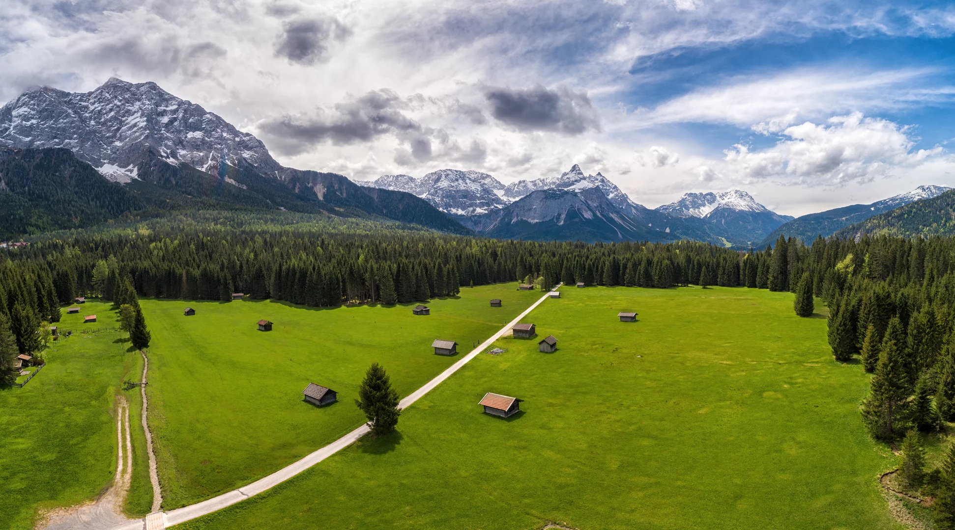 Spring in the Tiroler Zugspitz Arena | © Tiroler Zugspitz Arena | Danijel Jovanovic A green meadow with snow-covered peaks behind it | © Tiroler Zugspitz Arena | Danijel Jovanovic
