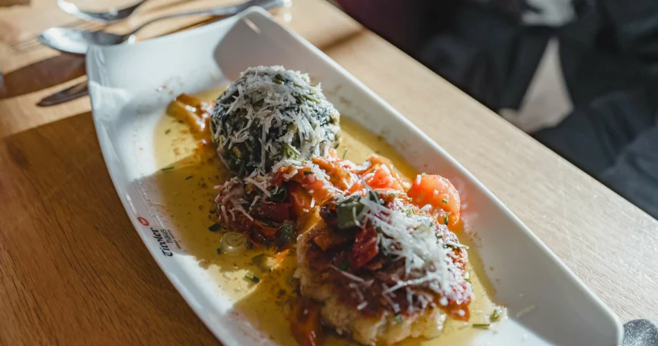 A spinach dumpling and a cheese dumpling in butter with grated parmesan | © Tiroler Zugspitz Arena/Sam Oetiker