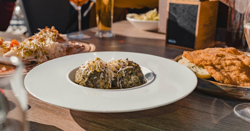 A portion of schnitzel and a portion of spinach dumplings on a table | © Tiroler Zugspitz Arena/Sam Oetiker