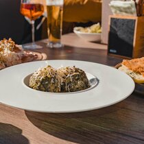 A portion of schnitzel and a portion of spinach dumplings on a table | © Tiroler Zugspitz Arena/Sam Oetiker
