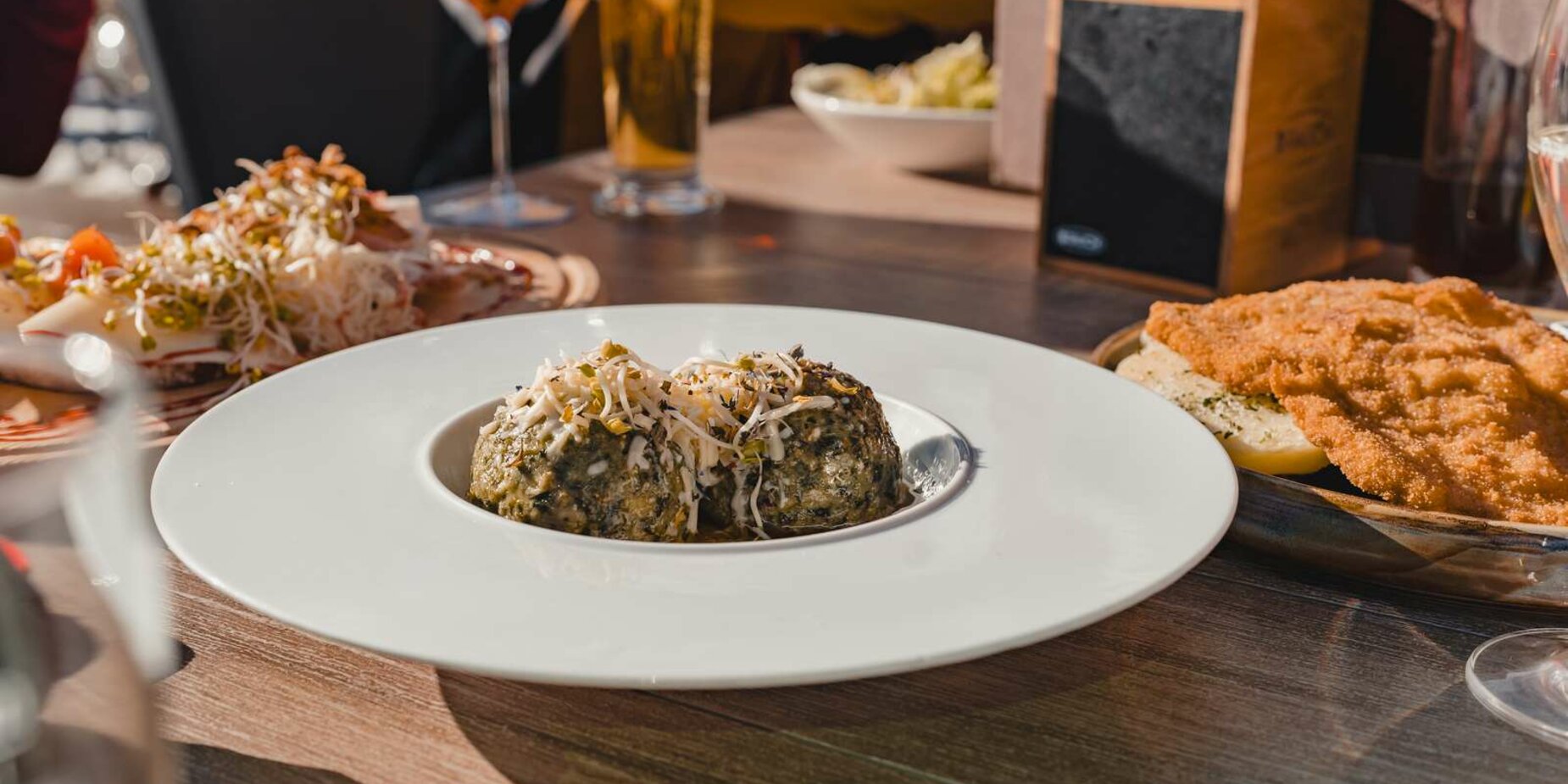 A portion of schnitzel and a portion of spinach dumplings on a table | © Tiroler Zugspitz Arena/Sam Oetiker