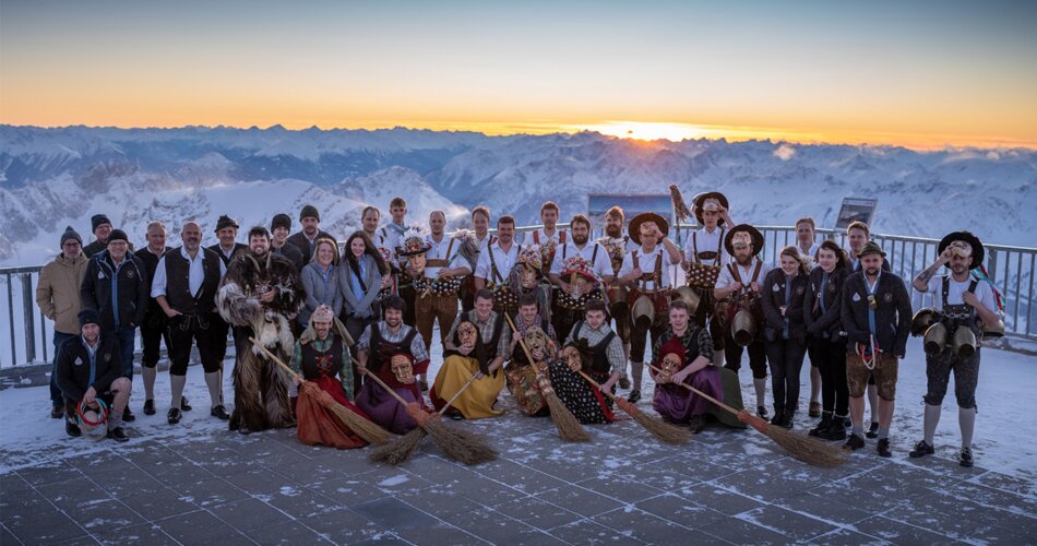 Eine Gruppe von Personen in Tiroler Tracht, im Hintergrund Bergpanorama | © michaelherczeg
