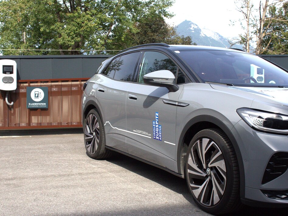 A gray car parked in front of a white e-charging station | © TZA