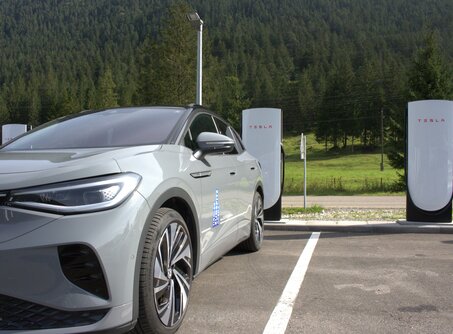 A gray car parked in front of two white Tesla e-charging stations | © TZA
