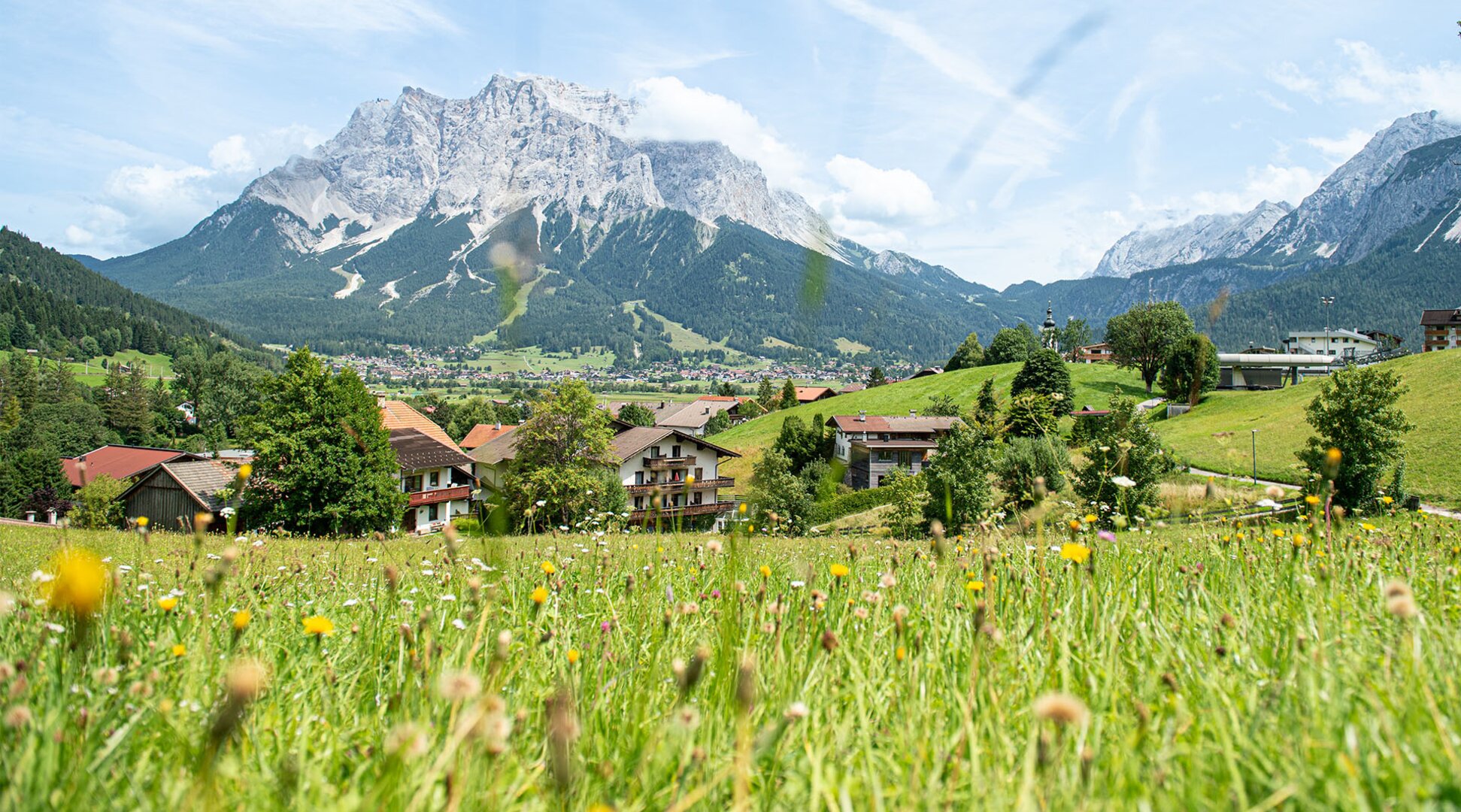 The Zugspitze, blooming meadows, and the village of Lermoos | © Tiroler Zugspitz Arena