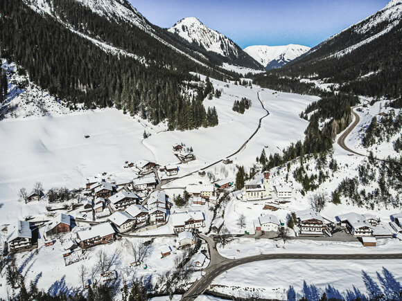 A drone shot of the village of Namlos in winter