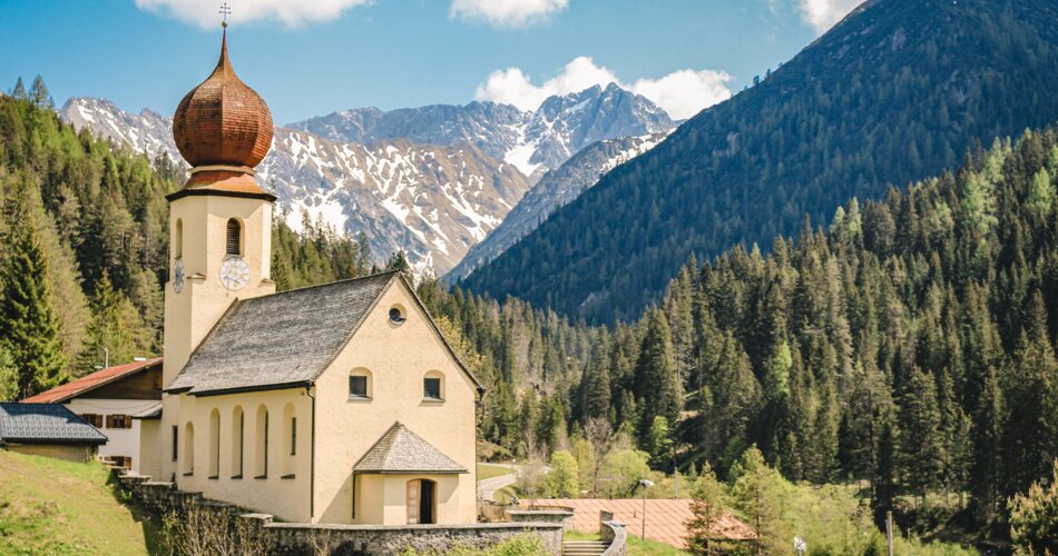 Eine Kirche und hohe Berge | © Tiroler Zugspitz Arena