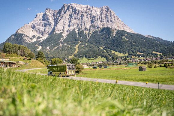 Ein Bus mit Fahrradhalter, im Hintergrund die Zugspitze | © Tiroler Zugspitz Arena/Nikola Radovic