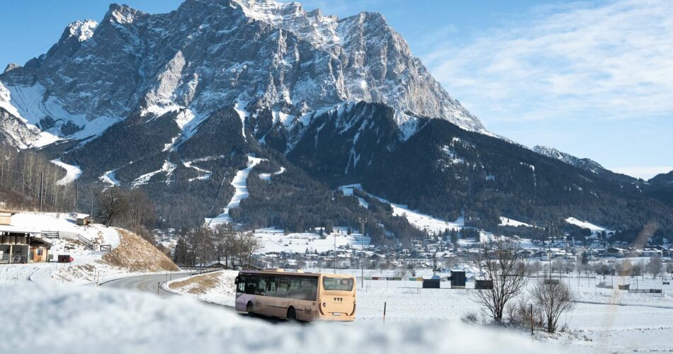 A VVT bus, with the Zugspitze mountain in winter behind it | © Tiroler Zugspitz Arena