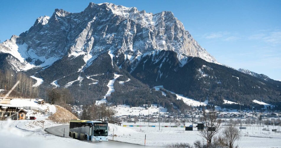 Ein VVT Bus, dahinter die Zugspitze im Winter | © Tiroler Zugspitz Arena