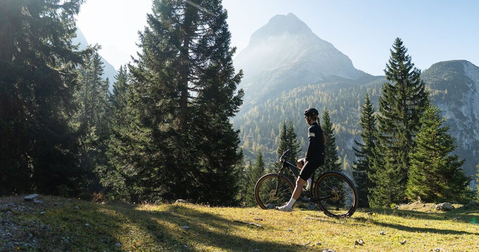 Eine Mountainbikerin vor Bergpanorama | © Tiroler Zugspitz Arena/Nikola Radovic