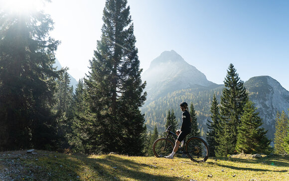 A mountain biker in front of a mountain panorama | © Tiroler Zugspitz Arena/Nikola Radovic