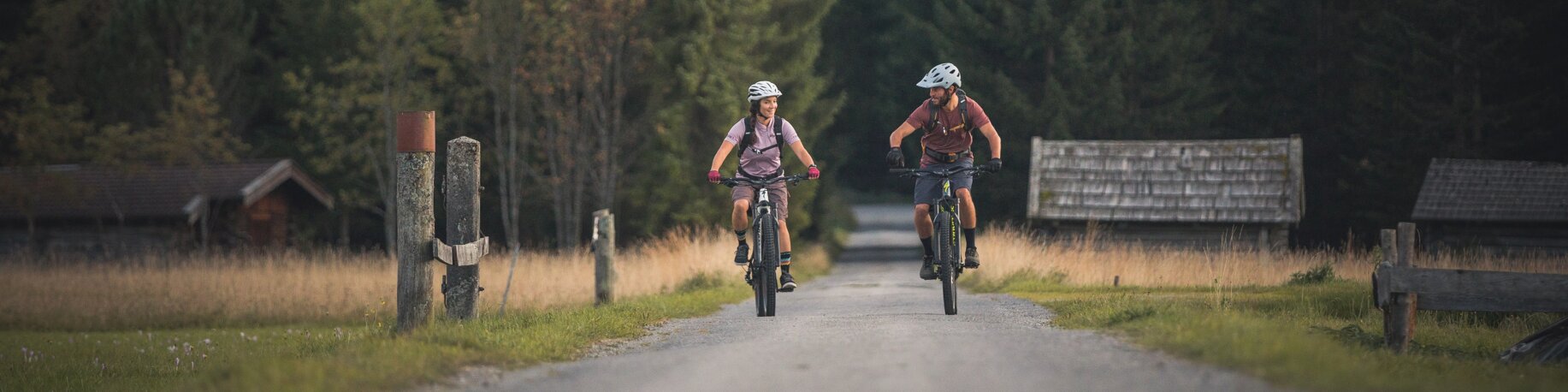 Zwei Radfahrer auf einer Straße, dahinter Wald und Berge | © Tiroler Zugspitz Arena/C. Jorda