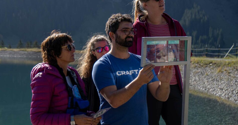 Several people solve a puzzle on a transparent plate