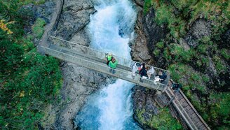Mehrere Personen auf einer Brücke, welche über die spektakuläre Rotlechschlucht führt | © Tiroler Zugspitz Arena/Schennach Valentin