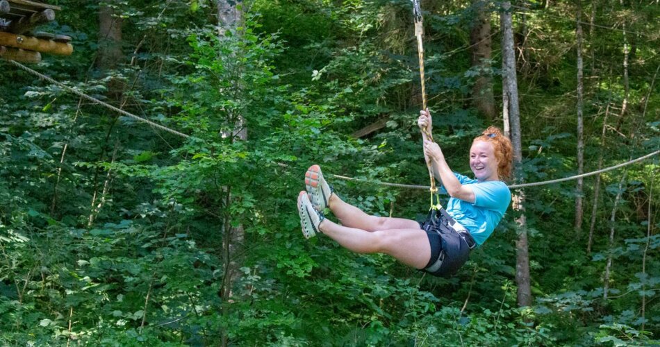 A woman laughs in the climbing forest | © Tiroler Zugspitz Arena/ Giovanni Frey