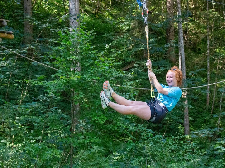 Eine Frau im Kletterwald lacht | © Tiroler Zugspitz Arena/ Giovanni Frey